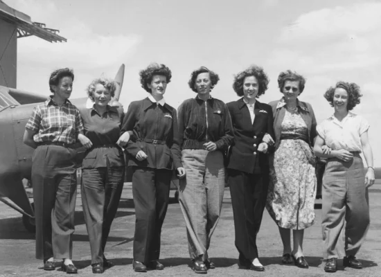 a group of women standing in front of the plane